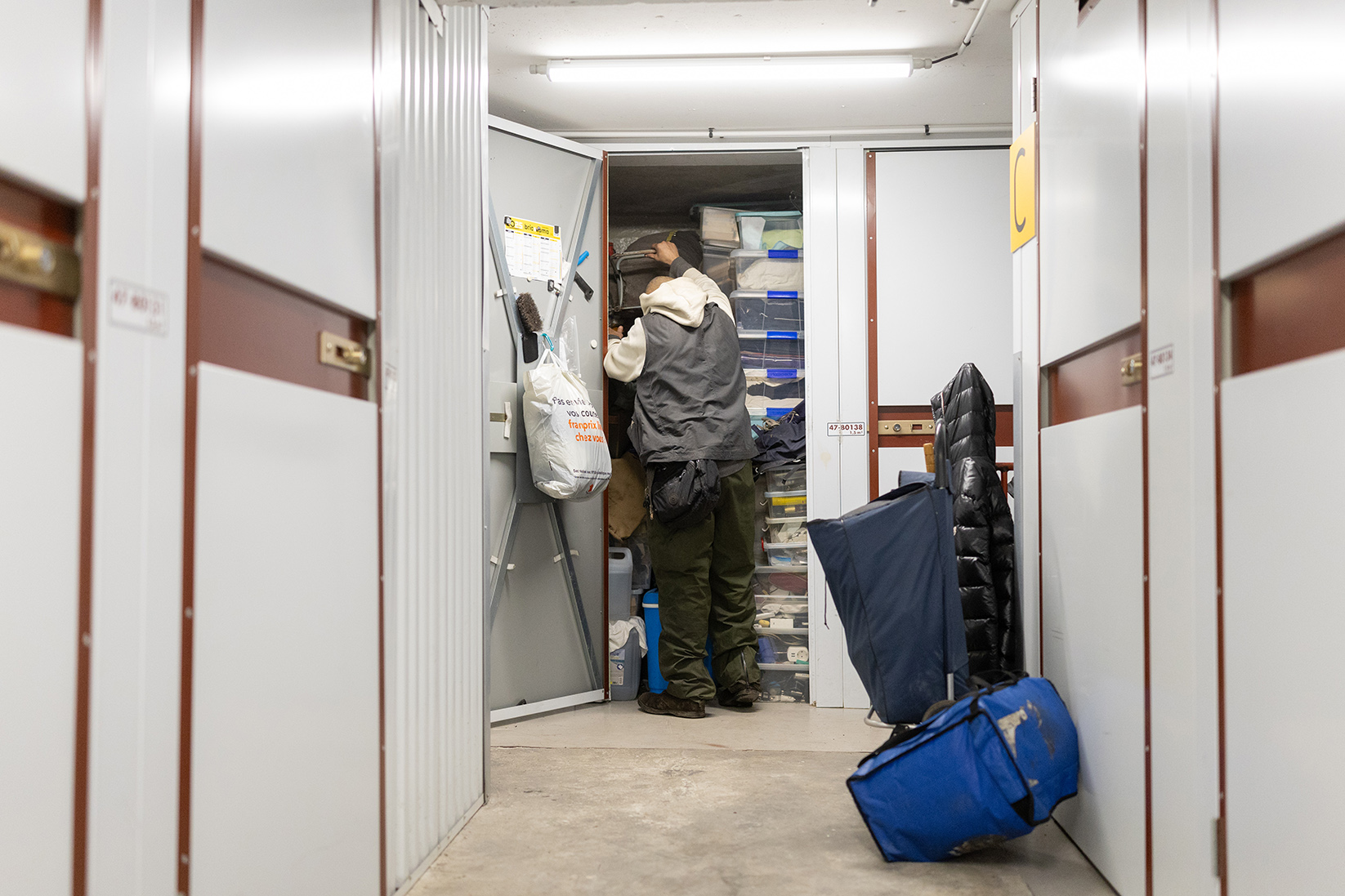 un homme sans-abri range ses affaires dans un garde-meuble