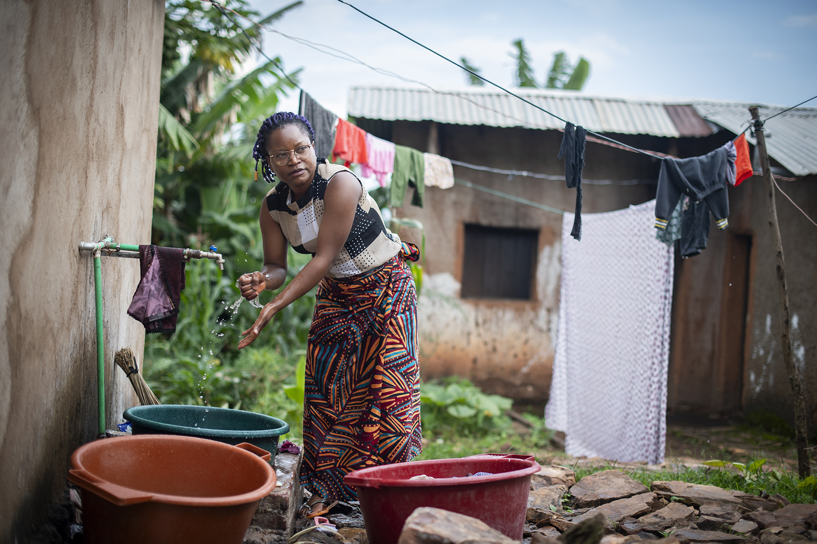 annick habitante du burundi lave son linge à la main