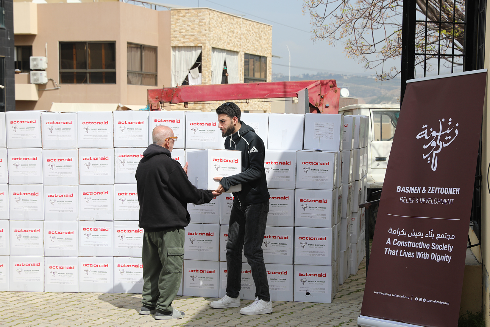 deux hommes livrent de l'aide humanitaire aux déplacés au liban en pleine guerre