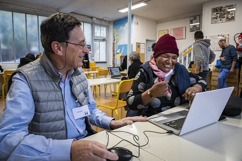 Au "Clic 24" de Puteaux, un bénévole accompagne une personne dans l'usage d'un ordinateur.