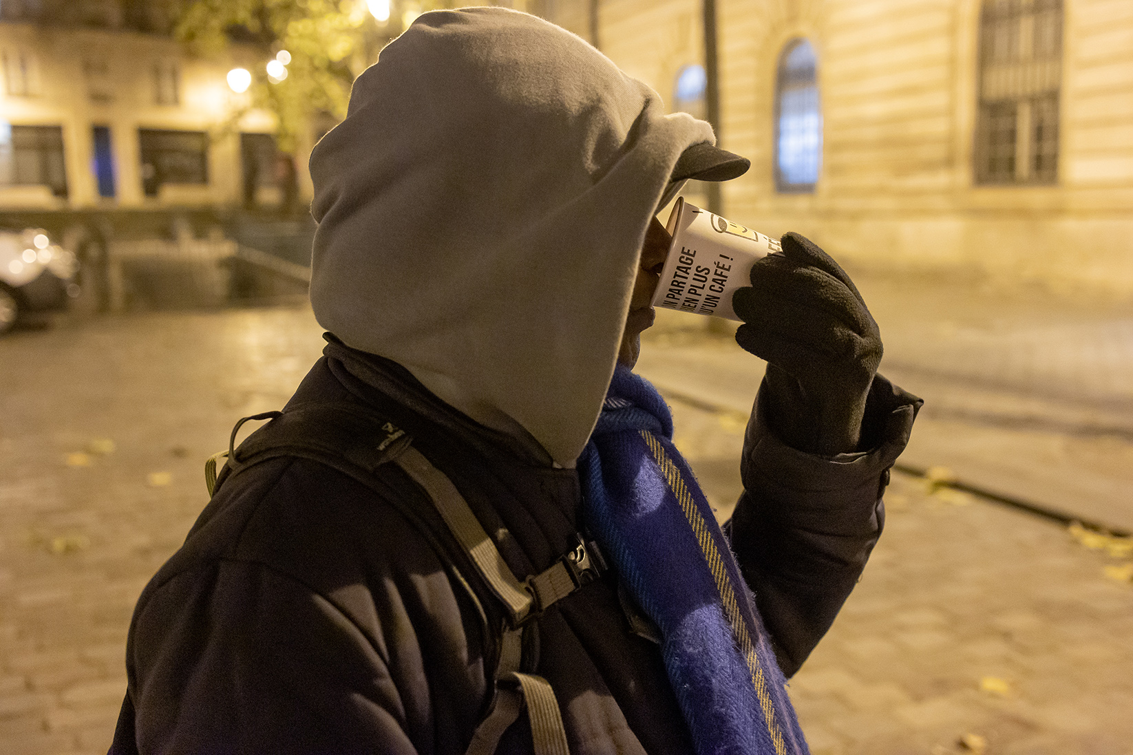 une personne à la rue buvant un café 