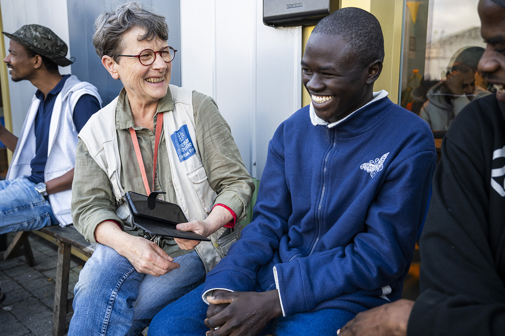 brigitte bénévole au secours catholique à côté d'une personne migrante à calais
