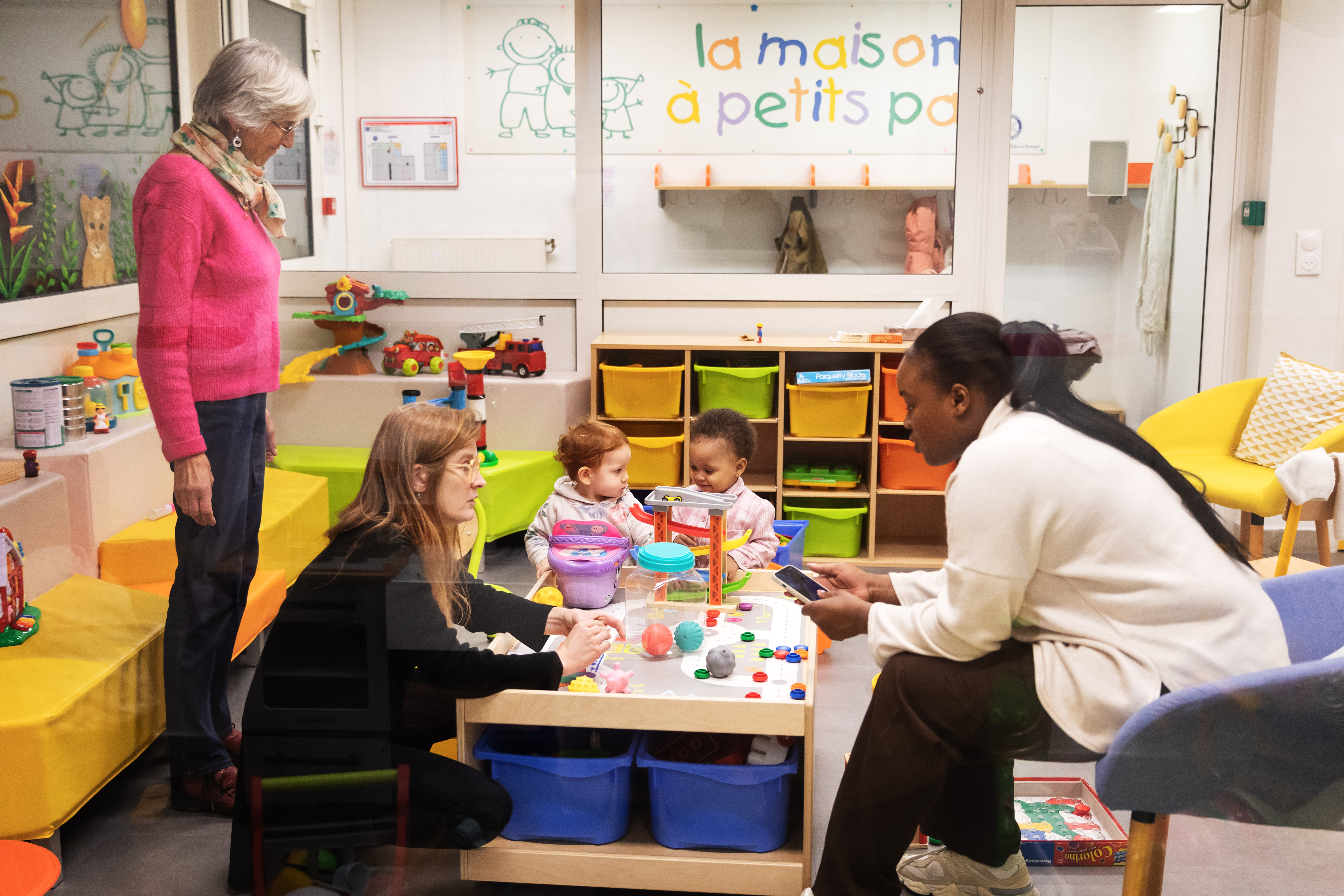 des mamans et des enfants jouent dans un espace du secours catholique