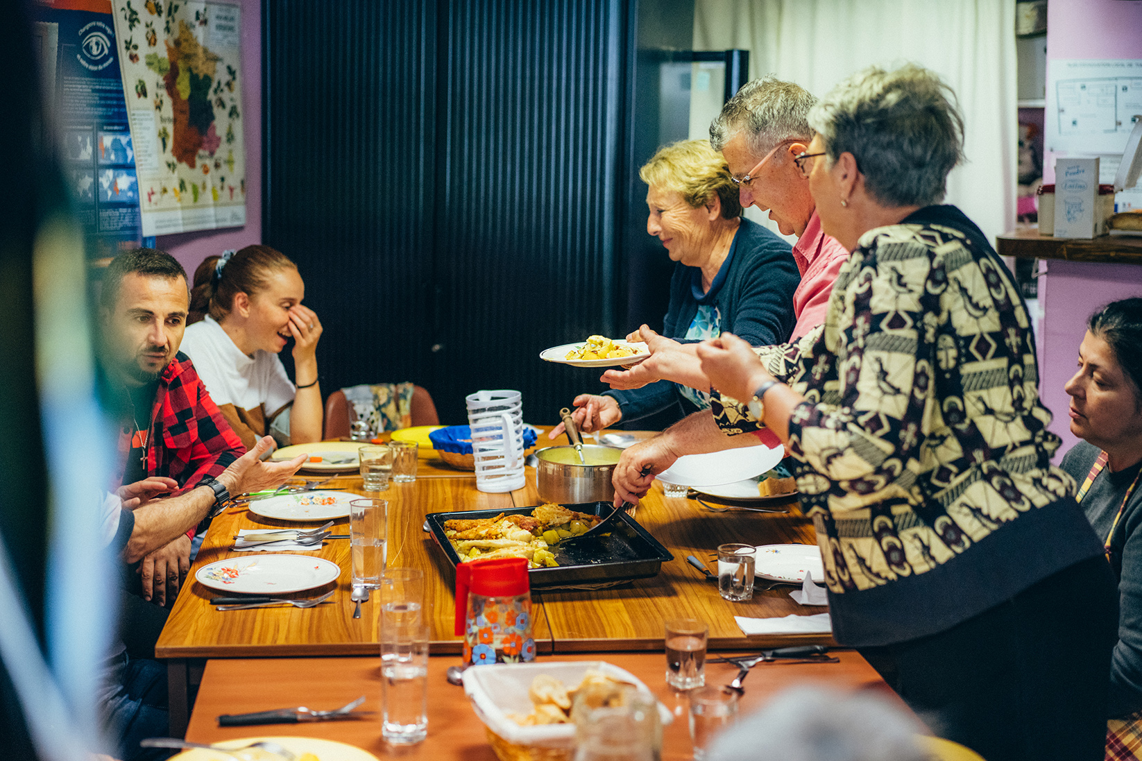 Des participants à l’atelier cuisine Pause popote sont rassemblés autour d’une table et partagent un repas.