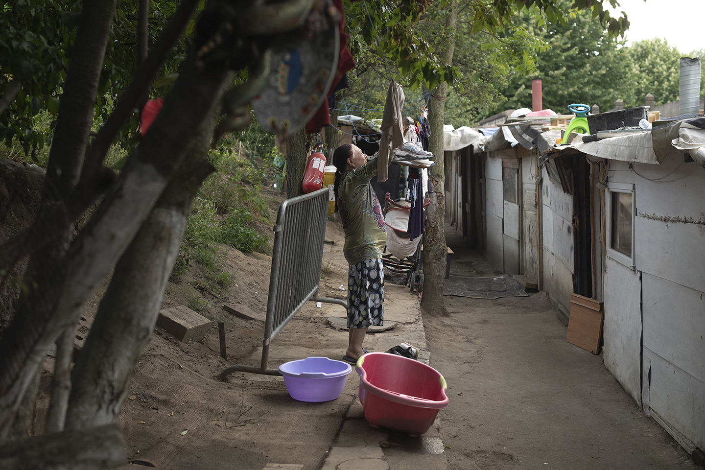 Vue du campement. Une femme étend du linge.