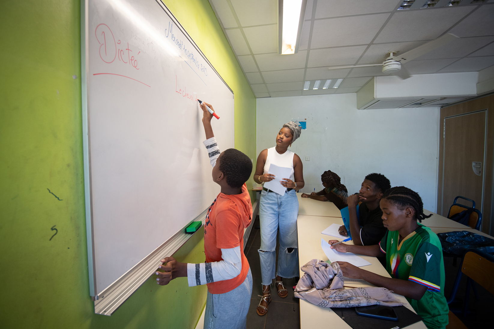 dans une salle de classe à mayotte un enfant écrit au tableau 