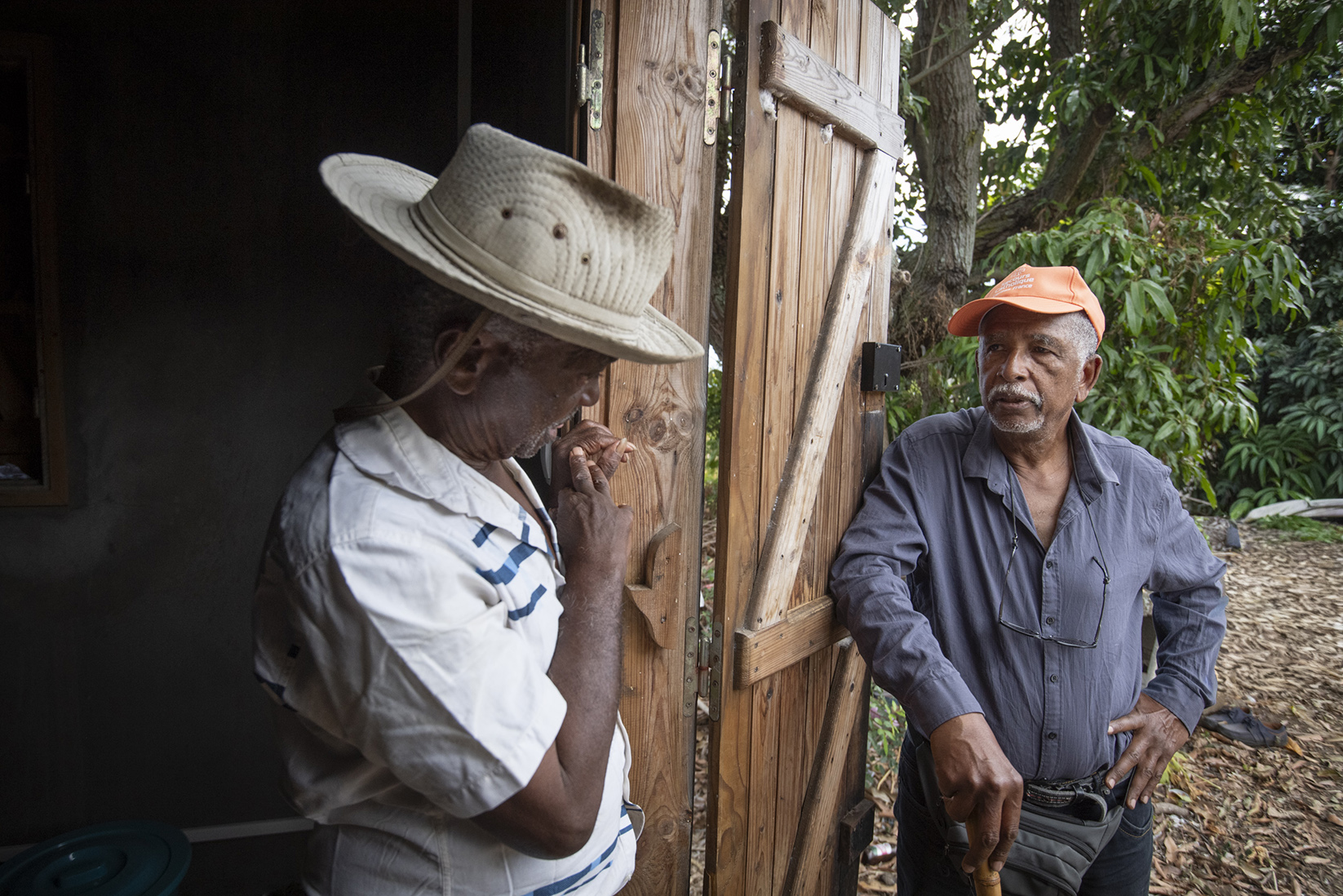 Ernest à la porte de sa case, avec Michel, bénévole