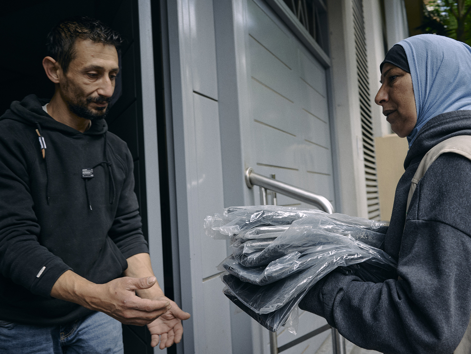 un homme recevant des couvertures dans un abri d'urgence à beyrouth