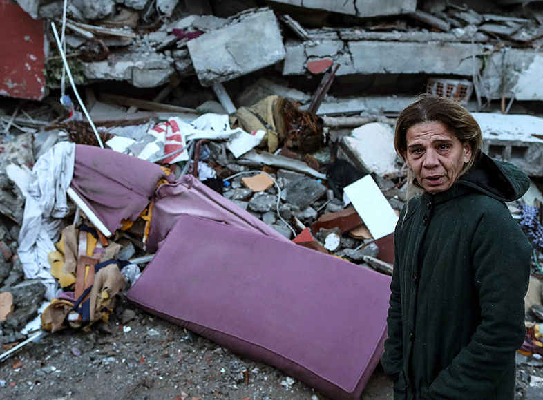 Une rescapée devant les décombres d'un immeuble, dans la province d'Hatay (Turquie).