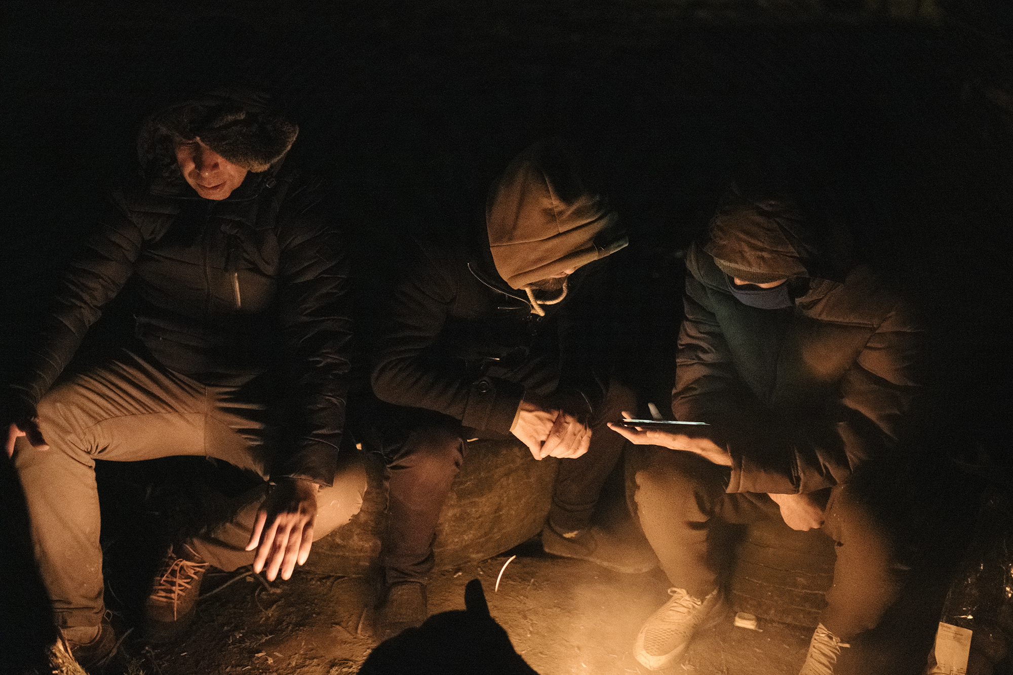 Un groupe d'Iraniens se réchauffe auprès d'un feu. La veille, les gendarmes sont venus les expulser du terrain où ils dorment. Le lendemain matin, ils déguerpiront avant leur arrivée. © Xavier Schwebel