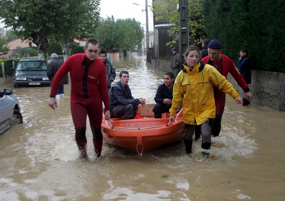 Des sauveteurs dans une rue inondée