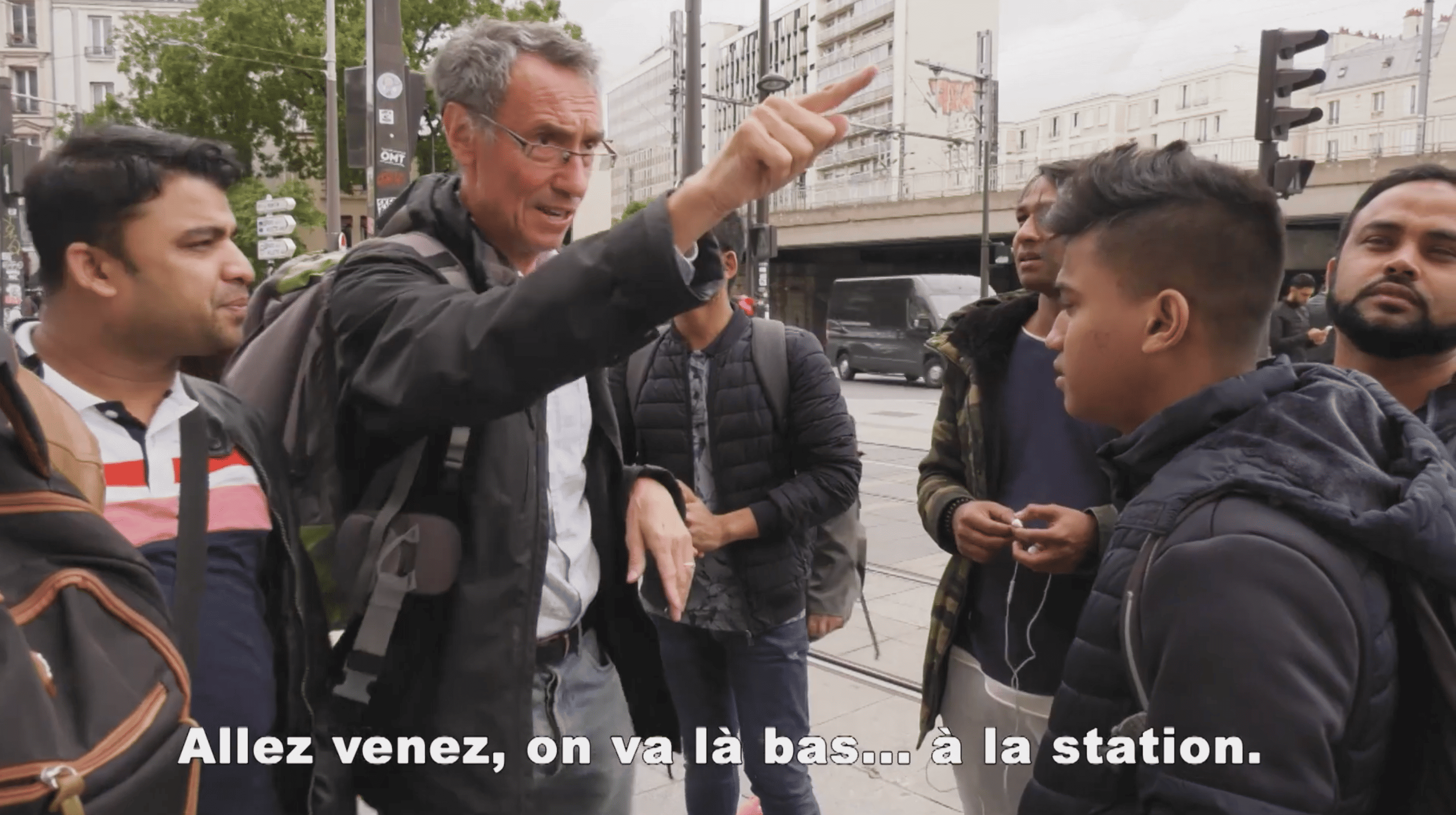 Un bénévole du secours catholique guide des personnes lors d'une visite de paris