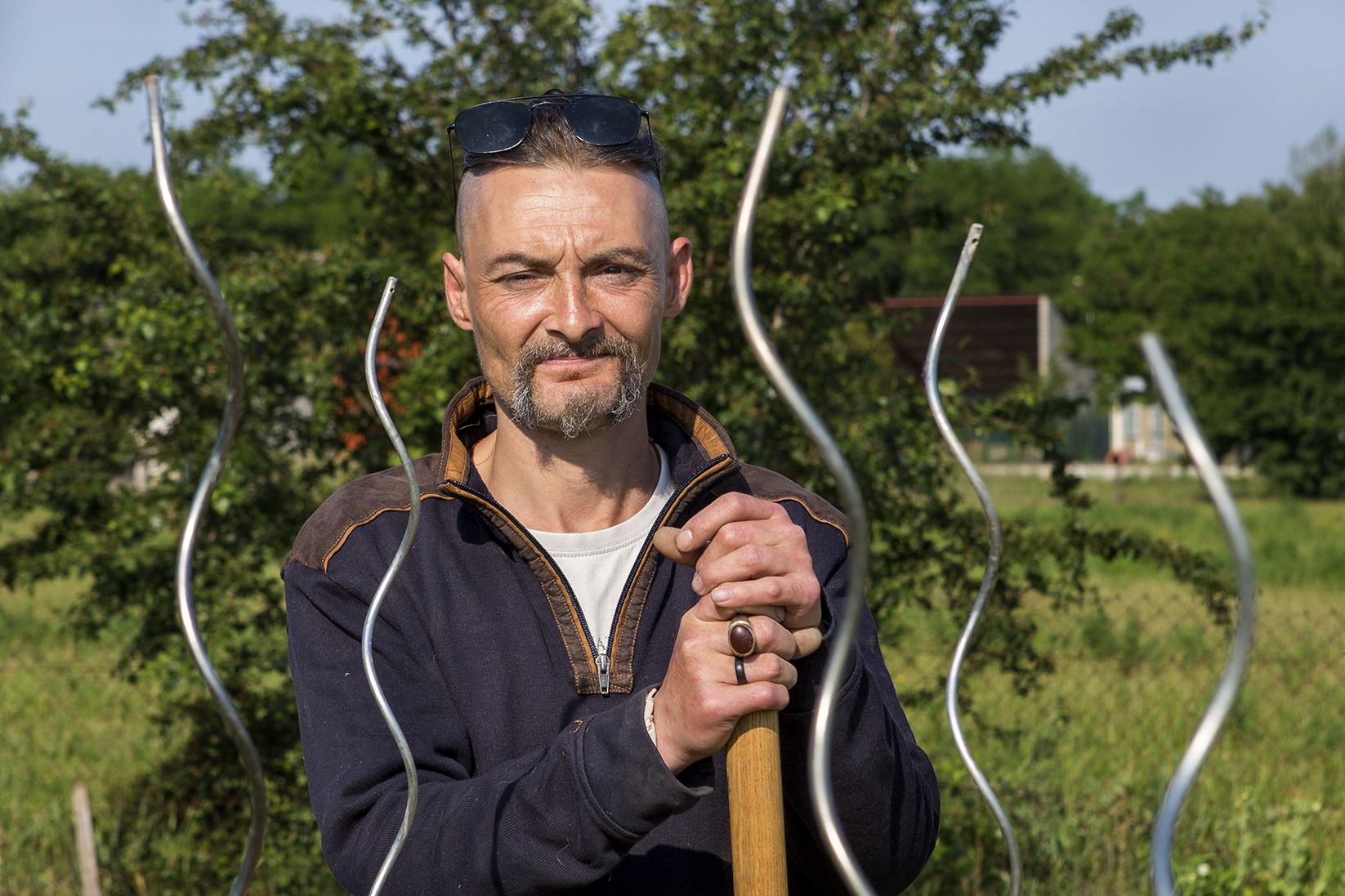 franky dans le jardin solidaire tient une pioche