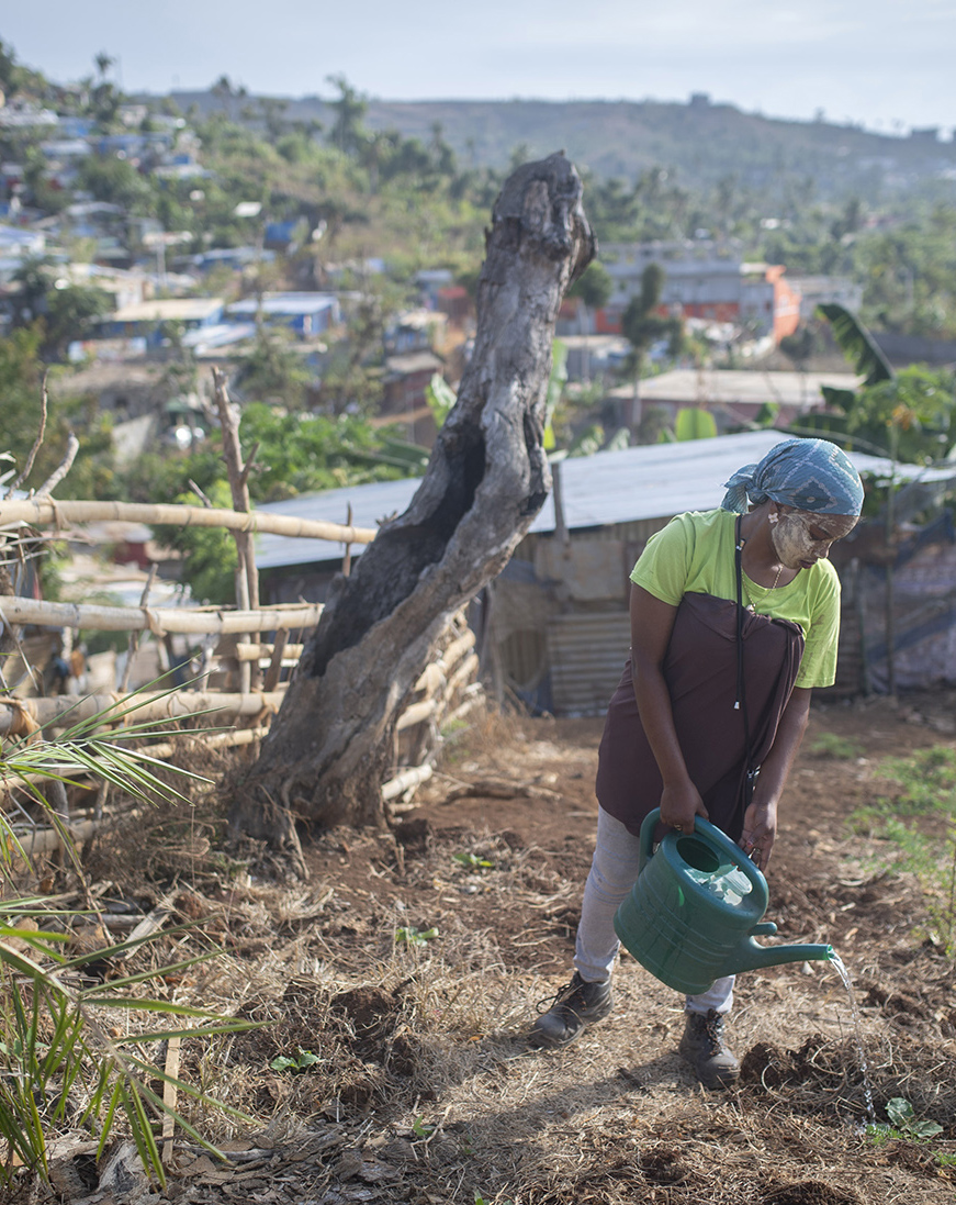 jeune femme arrosant une culture