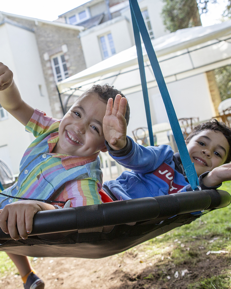 deux enfants sourient sur un trampoline