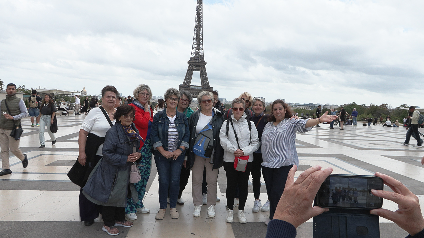 un groupe de vacanciers aidé par le secours catholique devant la tour effeil à paris