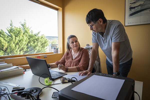 Géraldine, conseillère mobilité pour l'association FIT (Formation Insertion Travail) fait un point avec Gilles (président bénévole de l'association Solidarauto 43) dans son bureau situé au dessus de l'atelier.