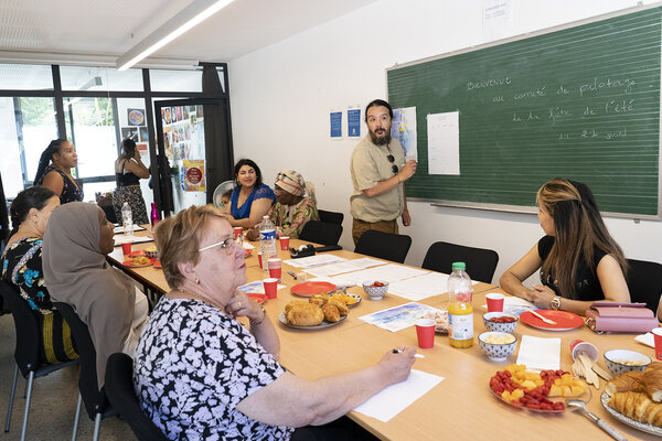 Dans la salle collective, autour de la table, les résidents organisent la prochaine fête.