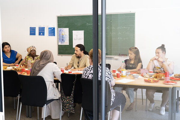 Dans la salle collective, autour de la table, les résidents organisent la prochaine fête.