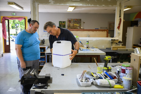 Dans un atelier, deux hommes au travail.