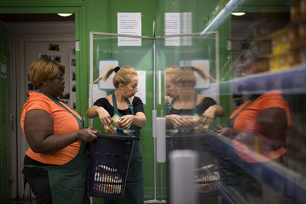 Mise en rayon de produits frais par deux bénévoles.