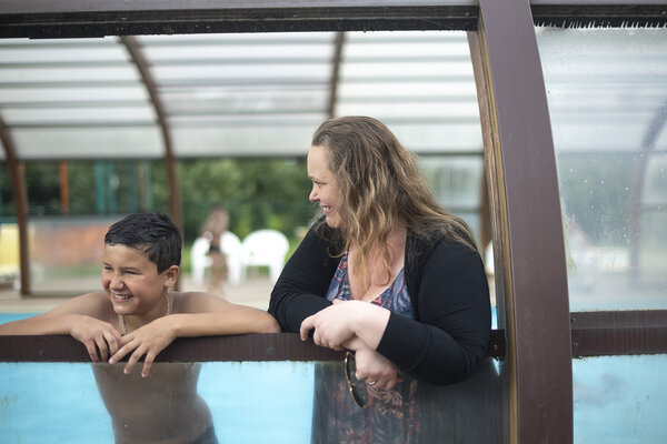 la mère avec un de ses fils à côté de la piscine du camping
