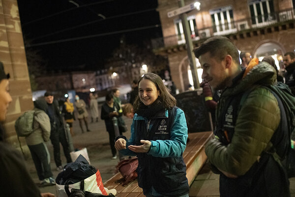 Maïwenn en discussion avec une personne à la rue.