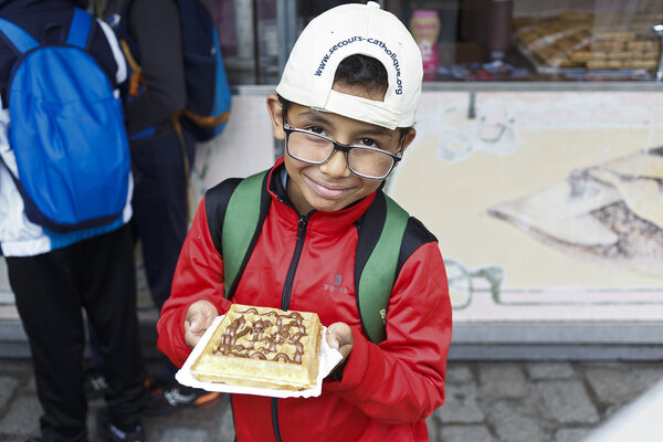 Un enfant montre la gaufre qu'il va déguster