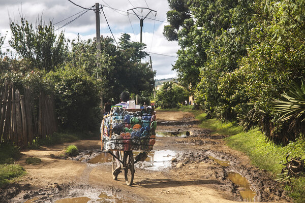 un vélo chargé de marchandises sur une route en terre madagascar