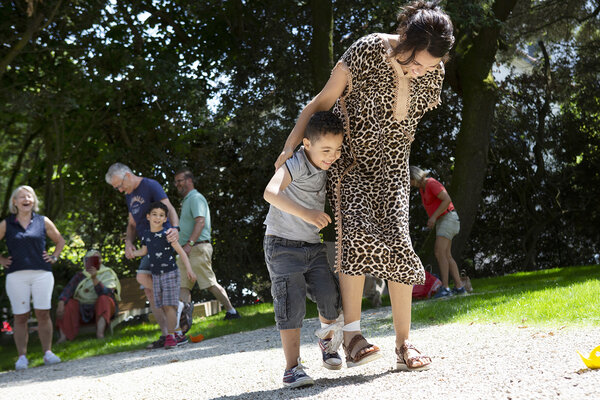 une mère et son jeune fils s'amusent à marcher avec un pied lié à l'autre
