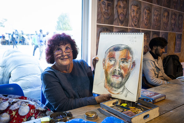 Portrait de Monique, bénévole à l'accueil de jour du Secours Catholique à Calais, montrant un de ses dessins