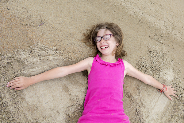 Jade, 8 ans, étendue sur le sable.
