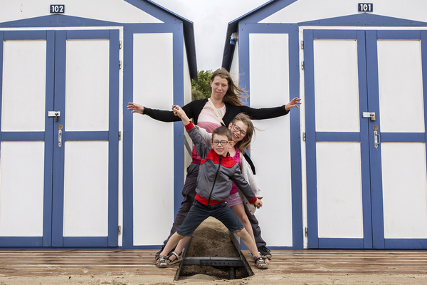 La famille pose devant une cabine de plage.