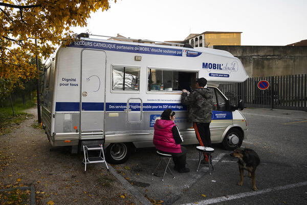 Carla et sa chienne, devant la douche mobile.