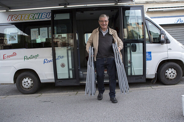 Olivier installe les chaises sous l'auvent du Fraternibus.