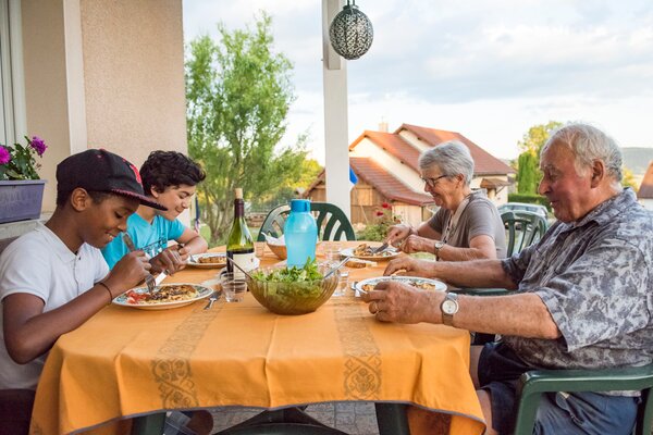 Les garçons, Monique et Louis à table pour le dîner.