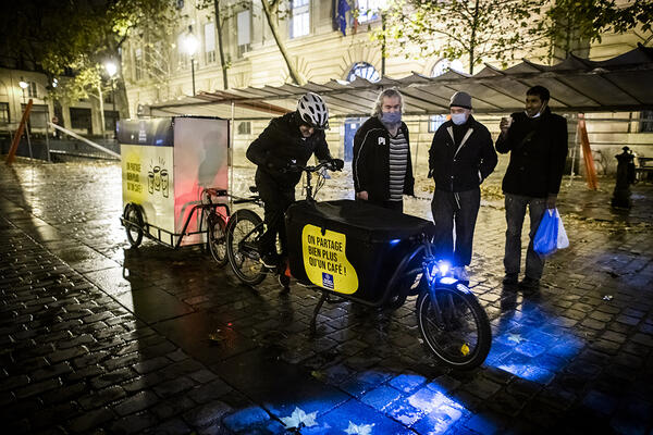 Le vélo triporteur utilisé pour le café de rue reprend la route.