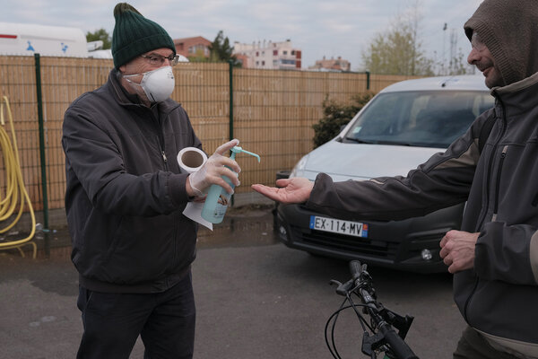 Enrico accueille avec une bouteille de gel hydroalcoolique.