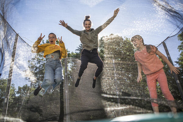 Trois jeunes vacanciers sautent sur un trampoline.