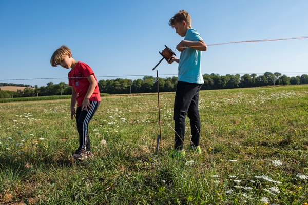 Les deux enfants aident à l'installation de la clôture.