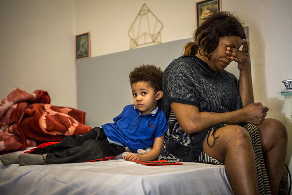 Justine et son fils, sur le lit de la chambre d'hôtel où ils vivent.