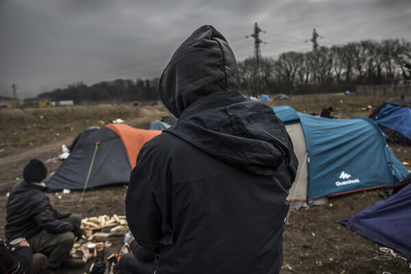 Un exilé de dos dans un campement.