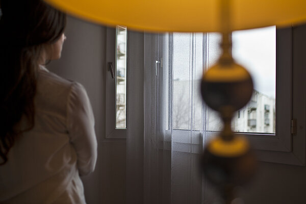 Une femme de dos dans son appartement.