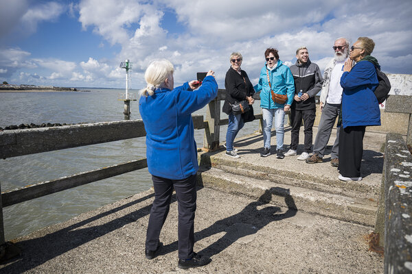 une bénévole prend le groupe en photo sur la jetée