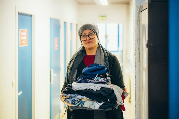 une femme portant une pile de vêtements