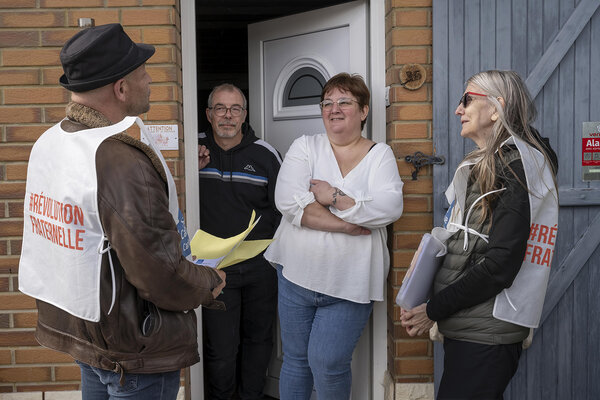 bénévoles et un couple sur le pas d'une porte