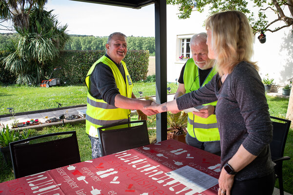 Marie, sinistrée, serre la main à un bénévole venu lui rendre visite