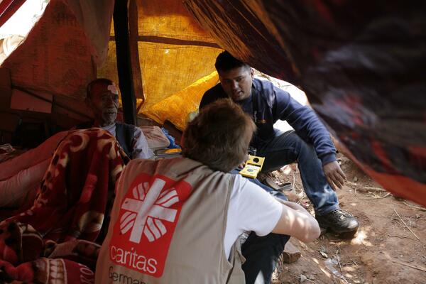 Un des membres de Caritas Germany  personnel de Caritas discute avec Buddhi Bahadur Banuar, une des victime du tremblement de terre âgée de 75 ans, près de Panchkhal dans le district de Kavrepalanchowk. 