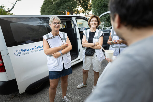 des bénévoles de la maraude du secours catholique discutent avec une personne à la rue