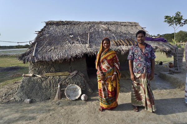 Deux villageois devant leur maison, au Bangladesh